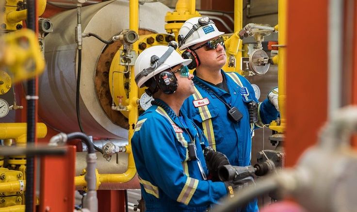 Field technicians in an industrial piping facility